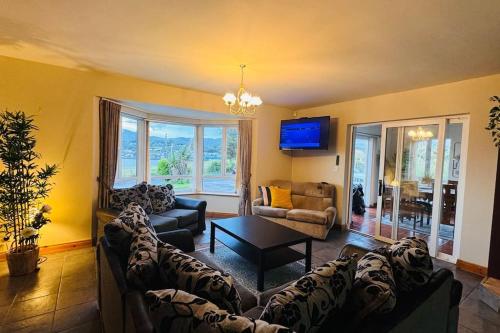 a living room with two couches and a tv at Benroe House 5 Bedrooms in Killybegs