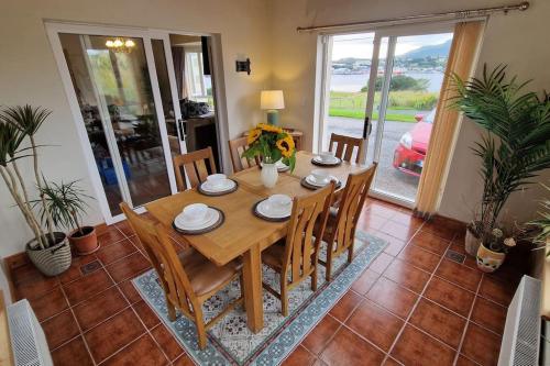 a dining room with a wooden table and chairs at Benroe House 5 Bedrooms in Killybegs