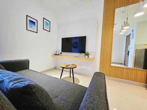 a living room with a couch and a tv at SummerDay Seaview Studio Apartment at Kota Kinabalu City Centre in Kota Kinabalu