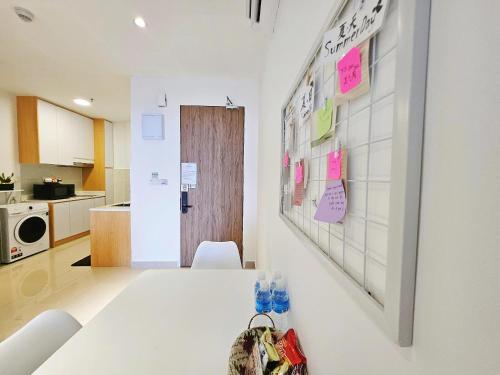 a white room with a table and a kitchen at SummerDay Seaview Studio Apartment at Kota Kinabalu City Centre in Kota Kinabalu