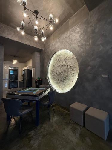 a dining room with a table and a large orb on the wall at 月出悠悠Moon Rise B&B in Hengchun