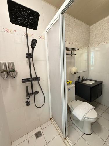 a bathroom with a shower with a toilet and a sink at 月出悠悠Moon Rise B&B in Hengchun