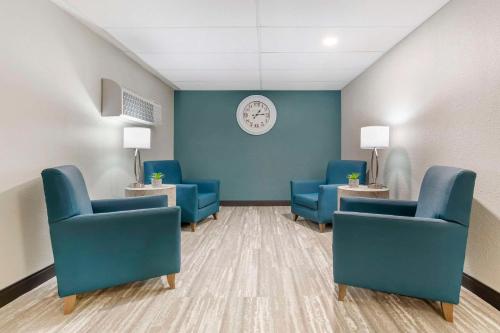 a waiting room with blue chairs and a clock at Quality Inn Hamilton Bitterroot Valley in Hamilton