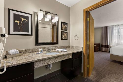 a hotel bathroom with a sink and a bed at Comfort Inn Ludington near US-10 in Ludington