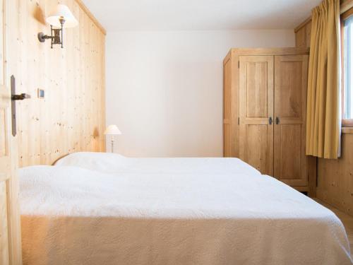 une chambre avec deux lits et une armoire en bois dans l'établissement Deux pièces, balcon sud/ouest, près des pistes à Tignes, Wifi exclu Juillet-Aout - FR-1-449-27, à Tignes