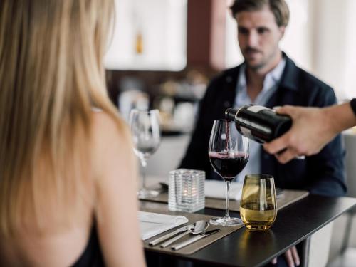 a man pouring wine into a wine glass at Spa Resort Geinberg in Geinberg