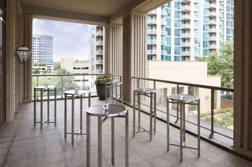 a balcony with tables and stools in a building at Waldorf Astoria Atlanta Buckhead in Atlanta