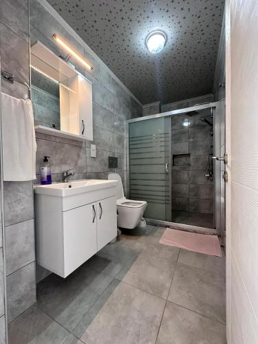 a bathroom with a toilet and a sink and a shower at Lavender Villas in Dalaman