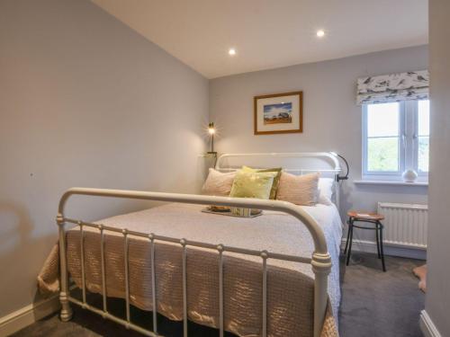 Schlafzimmer mit einem Bett mit Metallgitter in der Unterkunft Caines Cottage in Saxmundham
