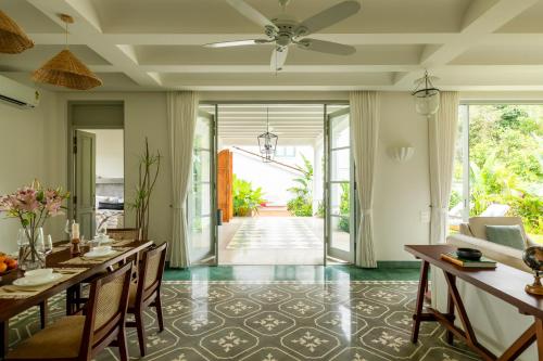 a dining room with a table and a ceiling fan at La Rozalia, Exquisite 4 BHK Villas with Large Pool, Garden, Dedicated Caretaker, Terrace, 2 mins from the famous Dear Zindagi Road in Mapusa