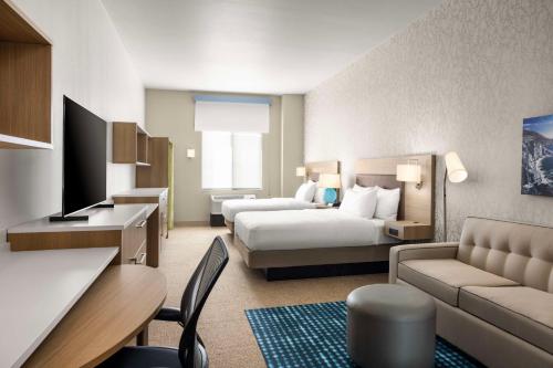 滨海城Home2 Suites By Hilton Marina的配有床和沙发的酒店房间
