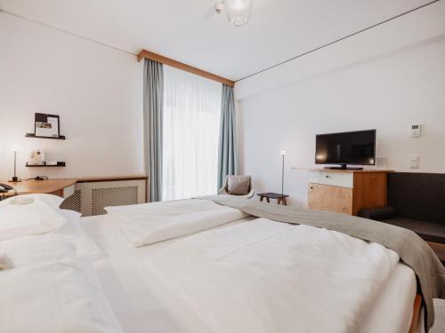 a hotel room with a large bed and a television at Spa Resort Geinberg in Geinberg
