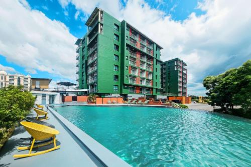 a swimming pool in front of a tall building at SureStay By Best Western Iconic Suvarnabhumi in Samut Prakan