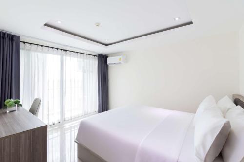 a bedroom with a white bed and a window at SureStay By Best Western Iconic Suvarnabhumi in Samut Prakan
