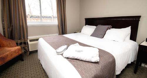 a hotel room with a bed with two towels on it at Elm Hurst Inn & Spa in Ingersoll