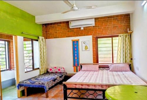 een slaapkamer met twee bedden en een bakstenen muur bij Yangzom Homez in Siliguri
