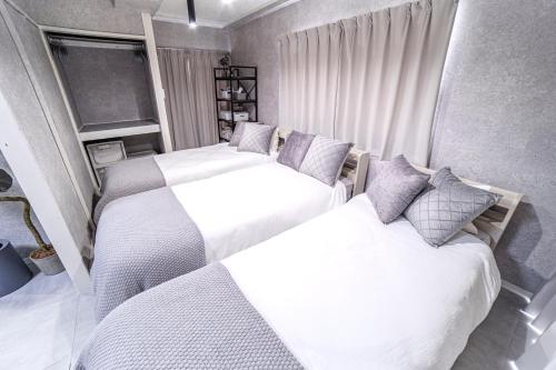 two beds in a bedroom with white and gray at 1 line to Asakusa! Projector, 5 mins walk from Togoshi-ginza Sta in Tokyo