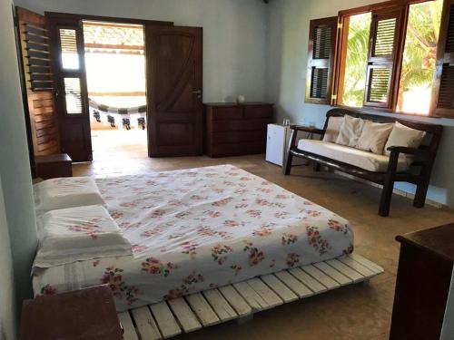 a bedroom with a bed and a couch and windows at Casa Cauipe Cumbuco in Paracumbuca
