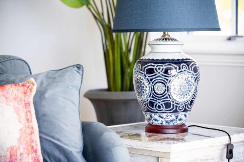 a blue and white vase on a table with a lamp at Stunning 4 Bedroom Farmhouse in Bishopton