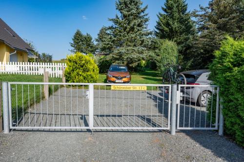 a gate with a car parked in a driveway at Ferienbungalow Poppengrün in Poppengrün