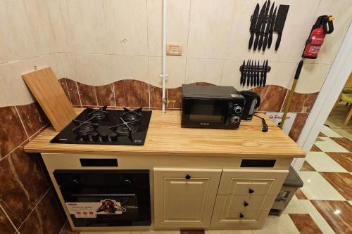 a kitchen with a stove and a microwave on a counter at Mansoura's sweet home hotel appartment 3 in Bandar al Manşūrah
