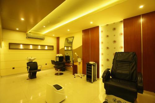 a room with a salon with a chair and a mirror at The Garuda Hotels in Trichūr