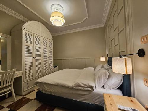 a bedroom with a bed with a lamp and a table at Mansoura's sweet home hotel appartment 3 in Bandar al Manşūrah