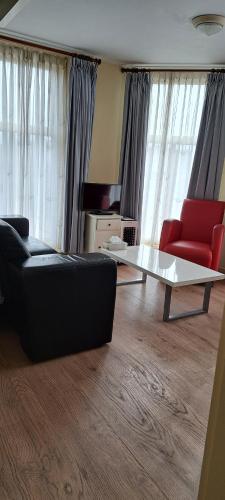 a living room with a couch and a table at Logement 'De witte klok' in Oude Bildtzijl