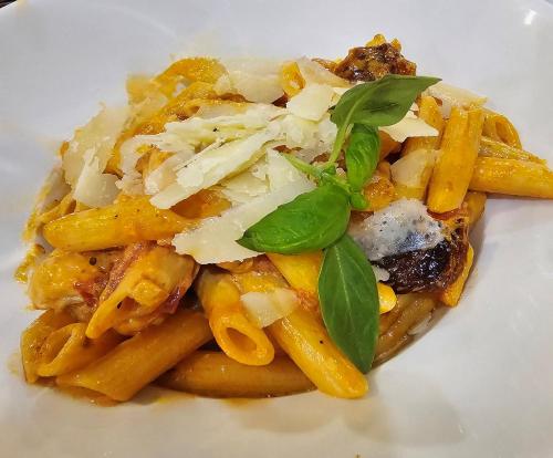 a plate of pasta with cheese and basil on it at Hanza Hotel in Rīga