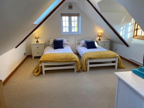 a bedroom with two beds in a attic at Riverside Cottage with balcony and fishing jetty in Upton upon Severn