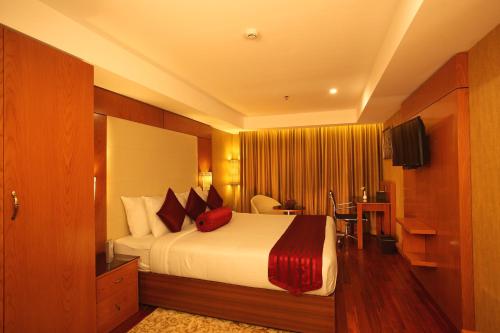 a hotel room with a bed with red pillows at The Garuda Hotels in Trichūr