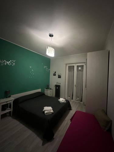 a bedroom with a black bed and a green wall at Family in Potenza