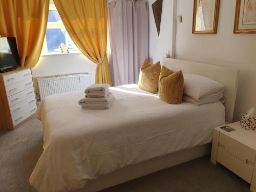 a bedroom with a bed with towels on it at Great for town & beach in Bournemouth