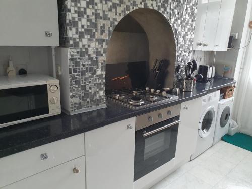 a kitchen with a stove top oven next to a microwave at Great for town & beach in Bournemouth