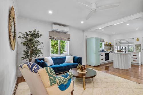 a living room with a blue couch and a table at La Petite Boheme-Pet friendly - boat parking in Cannonvale