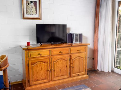 einen Fernseher auf einer hölzernen Kommode in der Unterkunft Holiday Home Koralle-1 by Interhome in Norddeich