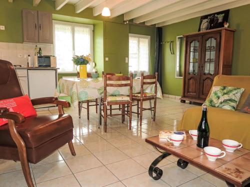 a living room with a table and chairs and a bottle of wine at Holiday Home L'Egven by Interhome in Matignon