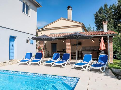 a group of chairs and umbrellas next to a swimming pool at Holiday Home Mariva by Interhome in Potpićan