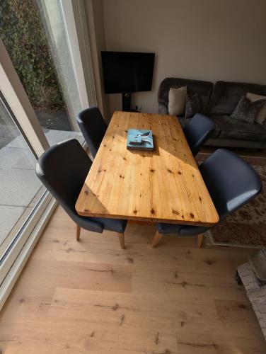 a wooden table in a living room with chairs at 19 Snowdon Apartment in Stirling