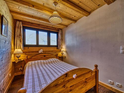une chambre dans une cabane en rondins avec un lit dans l'établissement Apartment La Lauze by Interhome, à La Toussuire