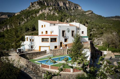 an external view of a house with a mountain in the background at Moli l'Abad in Puebla de Benifasar