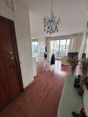 un salon avec un lustre et une table dans l'établissement Superbe appartement vue sur la Seine situé à Boulogne-Billancourt, à Boulogne-Billancourt