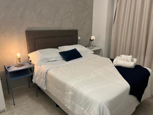 a bedroom with a large white bed and two night stands at Habitarte Brooklin in Sao Paulo