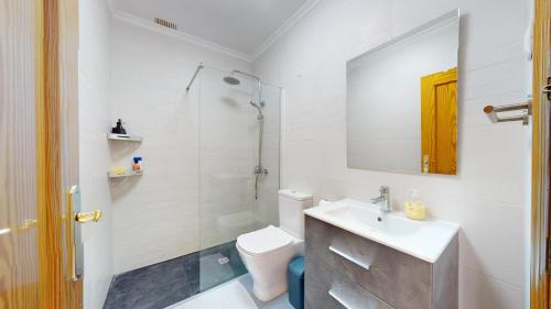 Un baño con lavabo, inodoro y espejo. en Holidoo Casa Marbella, en Los Alcázares