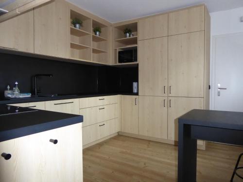 a kitchen with wooden cabinets and a black counter top at Family Mountain Winterberg Chalet privates Haus 10 Pers 4 Schlafzimmer WiFi near Lift in Winterberg