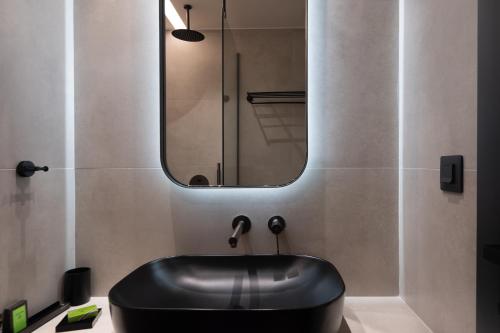 a black sink in a bathroom with a mirror at Nema Hotel Athens in Athens