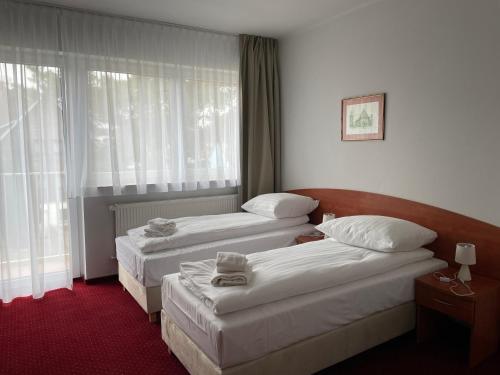a hotel room with two beds and a window at Nadmorski in Mrzeżyno