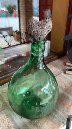 a green glass bottle sitting on top of a table at B&B Emma in Torreano
