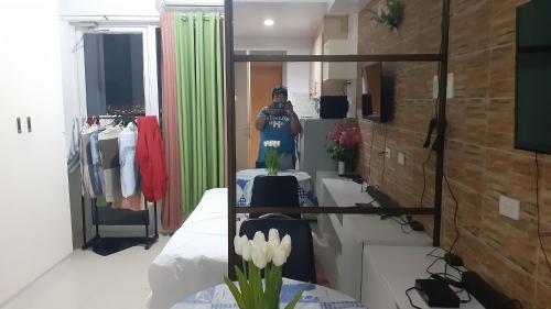 a woman taking a picture of herself in a bathroom mirror at Jinh's place to STAYCATION in Manila