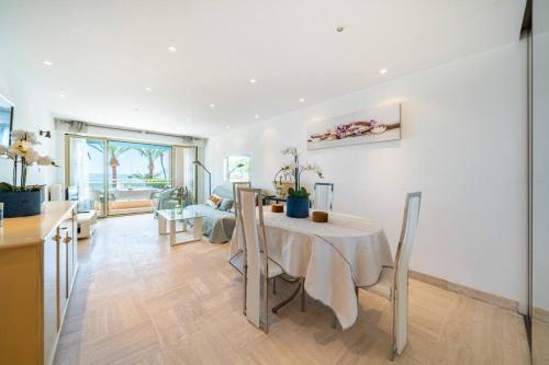 une cuisine et un salon avec une table et des chaises dans l'établissement Croisette vue mer 2 pièces, à Cannes